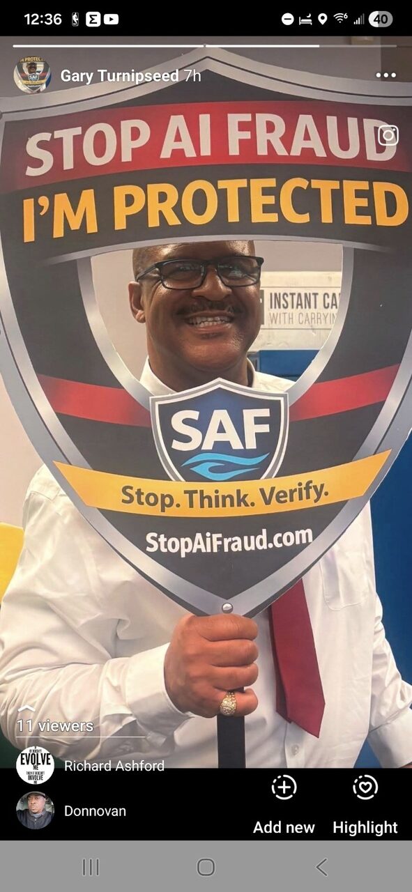 Gary Williams holding the StopAiFraud "I'm Protected" shield prop after a community session.